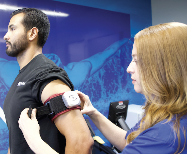 A patient and therapist with a blood flow cuff