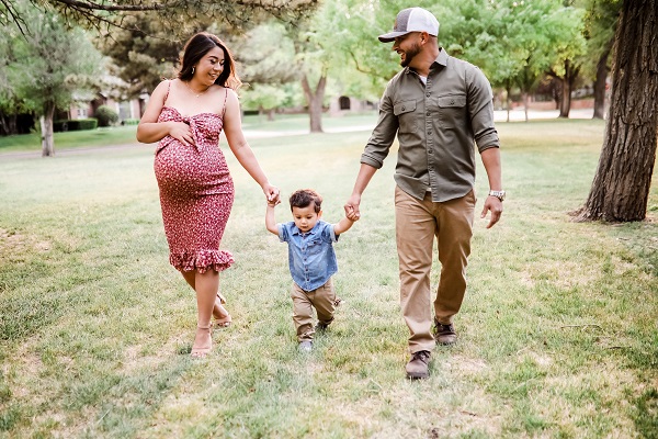 Alexis con su marido y su hijo paseando por un parque.