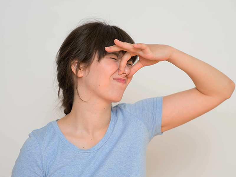 woman holding her nose