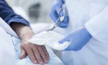 A doctor treating a hand wound