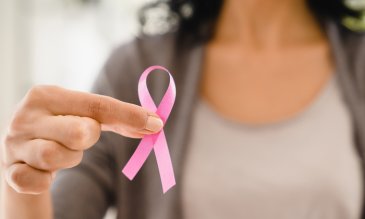 Woman holding pink ribbon for breast cancer awareness