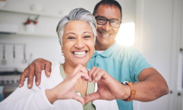 A man and woman making a heart symbol with their hands