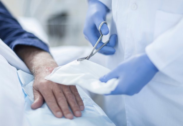 A doctor treating a hand wound