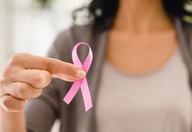 Mujer sosteniendo una cinta rosa para concientizar sobre el cáncer de mama