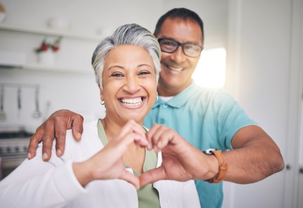 A man and woman making a heart symbol with their hands