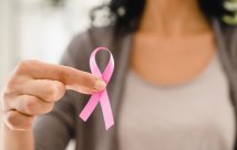 Woman holding pink ribbon for breast cancer awareness