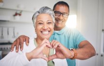 A man and woman making a heart symbol with their hands