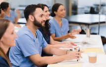Personas con uniformes médicos asistiendo a una conferencia